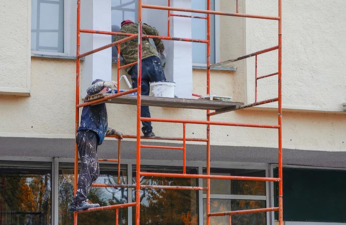 a painter painting exterior of commercial space