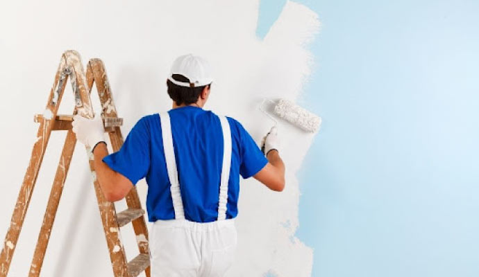 A professional painter painting a wall