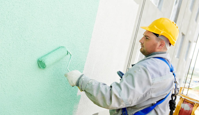a professional painting the outside of a building