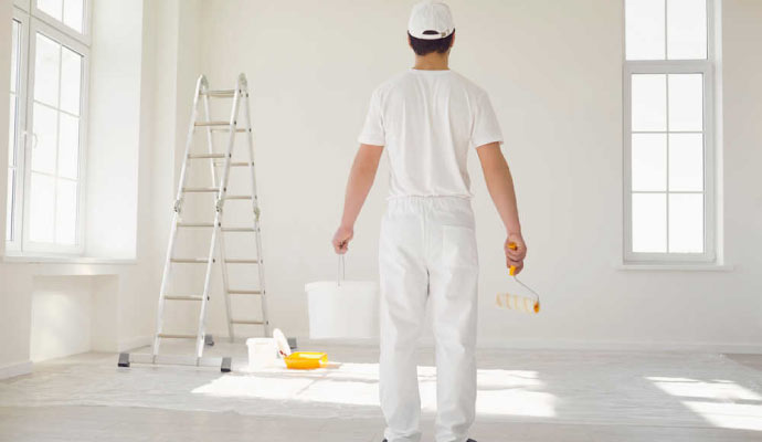 a painter painting the interior of a newly constructed building