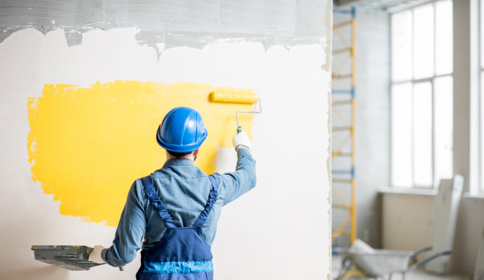 A Professional painter painting the wall of a parking garage