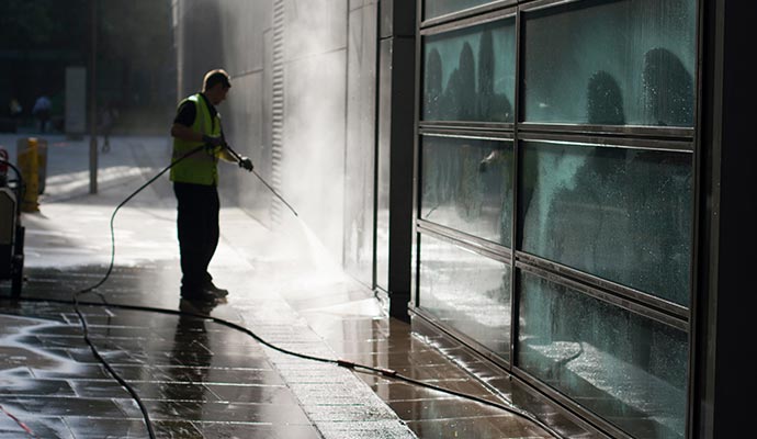 Commercial power washing cleaning outdoor surfaces.