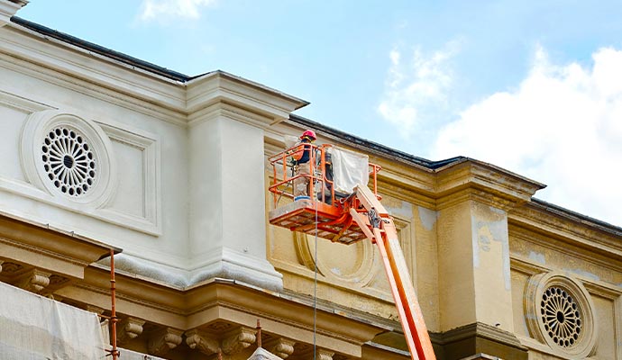 Expert worker repairing commercial stucco painting