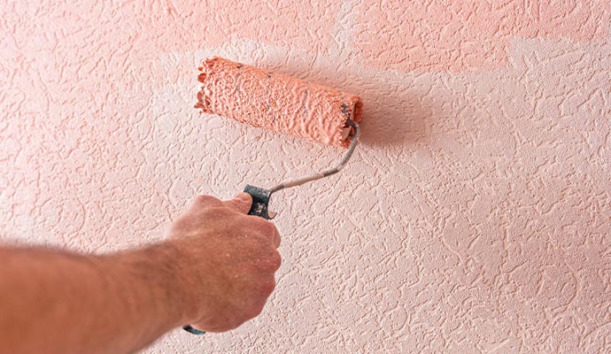 Professional painter stucco painting a wall