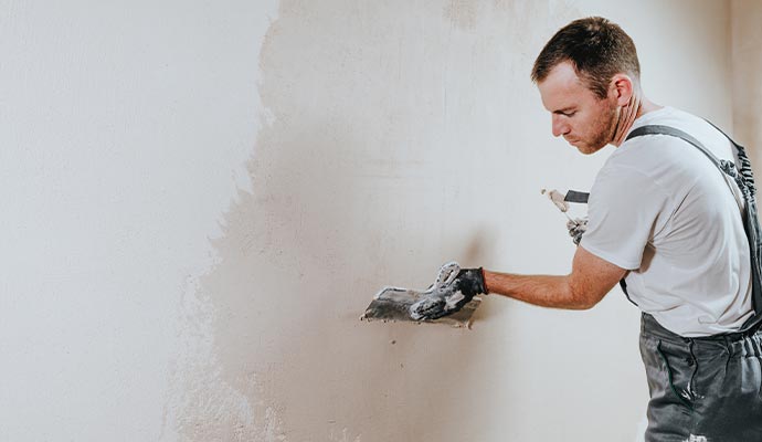 Professional painter repainting a stucco painted wall