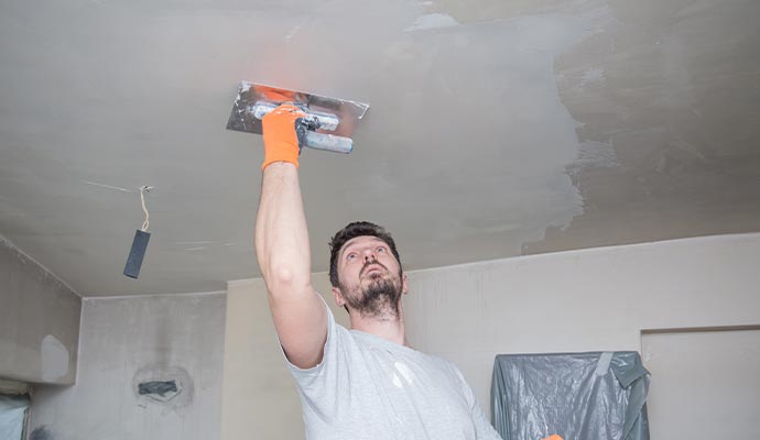 worker repairing concrete ceiling