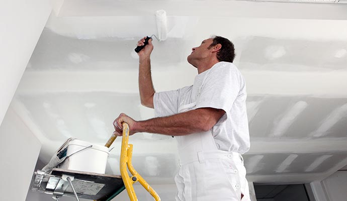 worker painting professionally in Fayetteville & Springdale