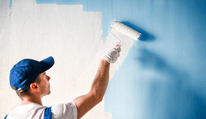 professional worker painting exterior of a building